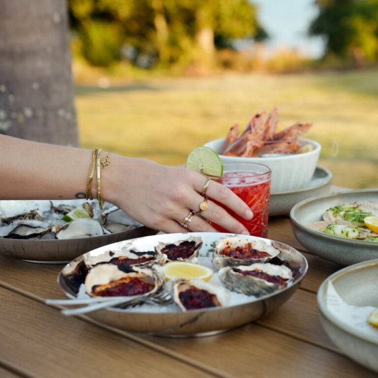 Plated seafood and shared plates with a cocktail